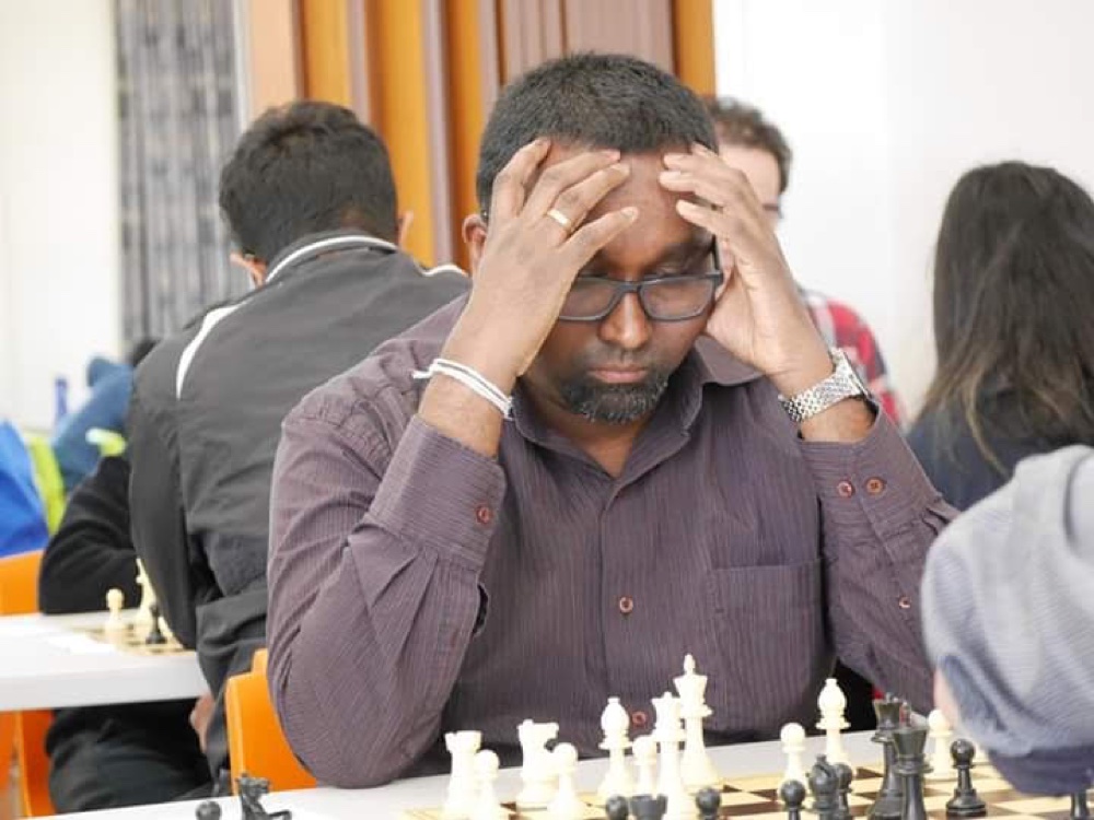 Roshan Gallage, FIDE Instructor, focused on a game at a chess tournament