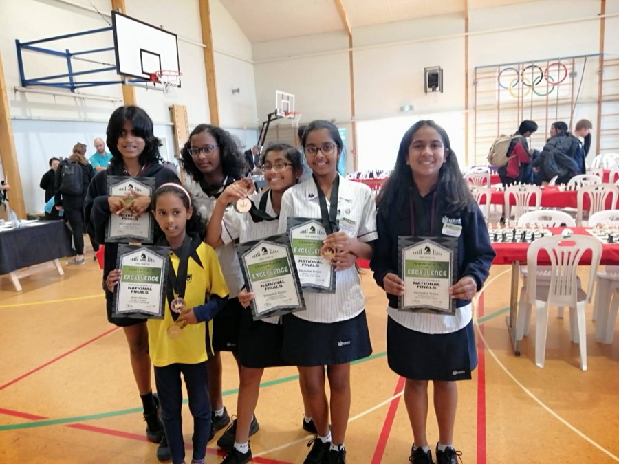 Students holding certificates and medals